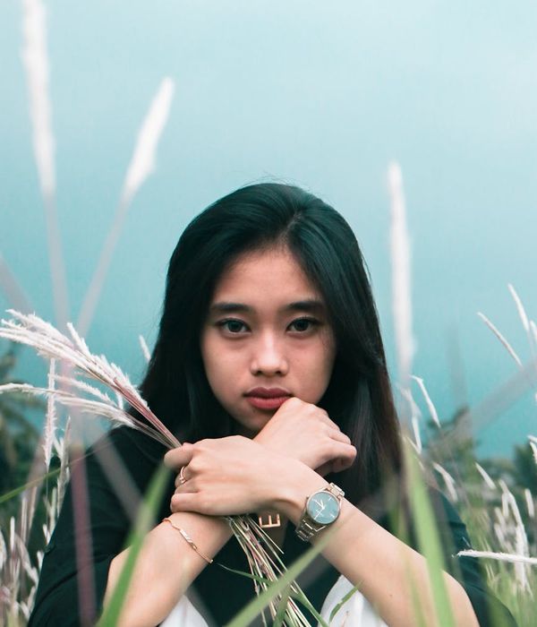 Person in a calm, focused pose against a serene backdrop.